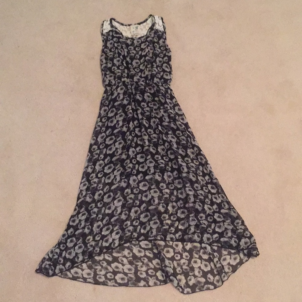 A girls dress that has grey and white flowers.